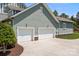 Spacious three-car garage with white doors and a wide driveway, surrounded by a well-maintained yard at 10822 Brandie Meadow Ln, Huntersville, NC 28078