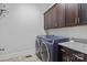 Modern laundry room with front-load washer and dryer, and dark cabinets at 10822 Brandie Meadow Ln, Huntersville, NC 28078