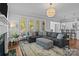 Open-concept living room with sectional couch and seamless flow to modern kitchen at 10822 Brandie Meadow Ln, Huntersville, NC 28078
