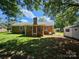 Exterior view of the home's backyard featuring a brick exterior, open green space, and a storage shed at 1109 Reid Harkey Rd, Matthews, NC 28105