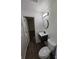 Modern bathroom with a black vanity, toilet, and a round mirror with an open doorway at 1109 Reid Harkey Rd, Matthews, NC 28105