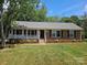 Charming one-story brick home features a covered porch and well-maintained landscaping at 1109 Reid Harkey Rd, Matthews, NC 28105
