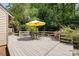 Outdoor deck featuring seating with a yellow umbrella, surrounded by lush greenery at 1160 Walton Pl, Salisbury, NC 28146
