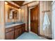 Classic bathroom with wood paneled walls, blue tile flooring, vintage-style vanity, and a well-lit mirror at 1160 Walton Pl, Salisbury, NC 28146