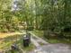 View of gated driveway entrance leading to the property amidst lush trees at 1160 Walton Pl, Salisbury, NC 28146