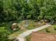 A well-maintained garden features plots, a shed, and a charming wooden playhouse, surrounded by lush greenery at 1160 Walton Pl, Salisbury, NC 28146