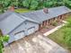 Home boasts a two-car garage, expansive driveway, and brick exterior, framed by lush greenery at 13030 Mayes Rd, Huntersville, NC 28078