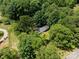 Aerial view of the home surrounded by mature trees and nearby roads at 13030 Mayes Rd, Huntersville, NC 28078
