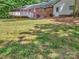 Expansive backyard features a wooden deck, well-maintained lawn, and classic brick accents, ideal for serene outdoor living at 13030 Mayes Rd, Huntersville, NC 28078