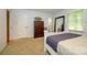 Bright bedroom with a tall dresser and a large mirror reflecting natural light at 13030 Mayes Rd, Huntersville, NC 28078