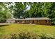 Charming brick ranch home with a lush, green front yard and mature trees at 13030 Mayes Rd, Huntersville, NC 28078
