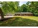 Charming brick ranch home with a three-car garage and lush green lawn, offering classic curb appeal at 13030 Mayes Rd, Huntersville, NC 28078
