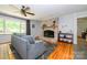 Living room featuring a brick fireplace, hardwood floors, and a comfortable sofa at 13030 Mayes Rd, Huntersville, NC 28078