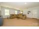 Spacious living room with large sectional sofa, carpeted floors, and natural light at 13030 Mayes Rd, Huntersville, NC 28078