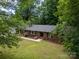 The home's exterior showcases a well-maintained lawn, brick facade, and mature landscaping at 13030 Mayes Rd, Huntersville, NC 28078