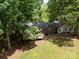 Aerial view of the home's rear exterior, featuring a spacious deck and mature trees at 13030 Mayes Rd, Huntersville, NC 28078