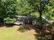 The home's exterior showcases a spacious deck, well-maintained lawn, and mature landscaping at 13030 Mayes Rd, Huntersville, NC 28078