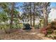 This wooded backyard features a charming fire pit area, perfect for outdoor entertaining and relaxation at 1308 Pennington Nw Pl, Concord, NC 28027