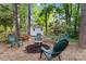 Enjoy a cozy backyard gathering space with comfortable seating and a tranquil, wooded atmosphere at 1308 Pennington Nw Pl, Concord, NC 28027