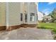 Backyard featuring yellow siding, a glass door, brick steps, patio, and manicured lawn at 1308 Pennington Nw Pl, Concord, NC 28027