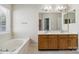 Bathroom with double sink, vanity, and tub with tile floors and large bright mirror at 1308 Pennington Nw Pl, Concord, NC 28027