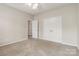 Neutral bedroom with carpeting, a ceiling fan, and a view of the door and closet at 1308 Pennington Nw Pl, Concord, NC 28027