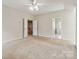 Carpeted primary bedroom with an ensuite bath entrance and stairs to the lower level at 1308 Pennington Nw Pl, Concord, NC 28027