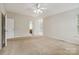 Large bedroom featuring neutral carpet, a ceiling fan, and an ensuite bathroom entrance at 1308 Pennington Nw Pl, Concord, NC 28027