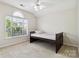 Bright bedroom featuring neutral carpeting, arched window and twin bed with headboard at 1308 Pennington Nw Pl, Concord, NC 28027