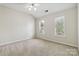 Bright bedroom featuring neutral carpeting, a ceiling fan, and windows dressed with blinds at 1308 Pennington Nw Pl, Concord, NC 28027