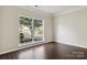 Empty room with wood-look tile floors and large window at 1308 Pennington Nw Pl, Concord, NC 28027
