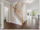 Welcoming foyer with wood-look tile floors and staircase with carpet and white railing at 1308 Pennington Nw Pl, Concord, NC 28027