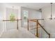 Bright second-floor hallway with wood railing, decorative lighting, and neutral carpet at 1308 Pennington Nw Pl, Concord, NC 28027