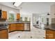 Bright kitchen showcasing oak cabinets, tile floors, with view into living room at 1308 Pennington Nw Pl, Concord, NC 28027
