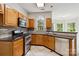 Well-lit kitchen boasts oak cabinetry, stainless steel appliances, and tile flooring at 1308 Pennington Nw Pl, Concord, NC 28027