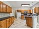 Open kitchen with oak cabinets, tile floors, and black countertops at 1308 Pennington Nw Pl, Concord, NC 28027