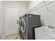 Well-equipped laundry room with washer, dryer, utility sink, tile floors, and a wire storage shelf at 1308 Pennington Nw Pl, Concord, NC 28027