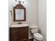 Traditional powder room featuring a wood vanity with marble countertop and decorative mirror at 1308 Pennington Nw Pl, Concord, NC 28027
