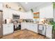 Bright kitchen featuring white cabinetry, stainless steel appliances, quartz countertops, and hardwood floors at 137 Ole Eastpointe Dr, York, SC 29745