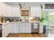 Bright kitchen featuring white cabinetry, stainless steel appliances, and quartz countertops, with a window overlooking the backyard at 137 Ole Eastpointe Dr, York, SC 29745
