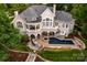 Stunning aerial view of a luxurious home with a pool, multiple outdoor living spaces, lush landscaping, and a grand design at 140 Lightship Dr, Mooresville, NC 28117