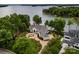 An aerial view of a luxury waterfront home with mature trees and a private dock on the lake at 140 Lightship Dr, Mooresville, NC 28117