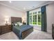 Comfortable bedroom featuring a wooden bed frame, blue bedding, and a large window with green curtains providing natural light at 140 Lightship Dr, Mooresville, NC 28117