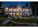 Expansive home exterior featuring a pool, outdoor seating, and manicured landscaping at twilight at 140 Lightship Dr, Mooresville, NC 28117
