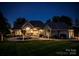 An exterior of a well-lit home at night with a beautifully landscaped yard and driveway at 140 Lightship Dr, Mooresville, NC 28117