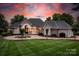 Stunning exterior of a grand home featuring manicured lawns and a beautiful sunset backdrop at 140 Lightship Dr, Mooresville, NC 28117