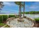 Cozy fire pit area with stone seating and scenic lake views, creating a perfect spot for gatherings and outdoor relaxation at 140 Lightship Dr, Mooresville, NC 28117