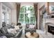 Comfortable living room featuring large windows with lake views, a fireplace, and elegant decor at 140 Lightship Dr, Mooresville, NC 28117