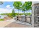 Well-equipped outdoor kitchen with stainless steel appliances, stone countertops, and picturesque lake views, ideal for outdoor dining at 140 Lightship Dr, Mooresville, NC 28117