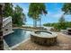 Beautiful pool area with a spa featuring stone detailing and serene lake views, creating a luxurious outdoor oasis at 140 Lightship Dr, Mooresville, NC 28117